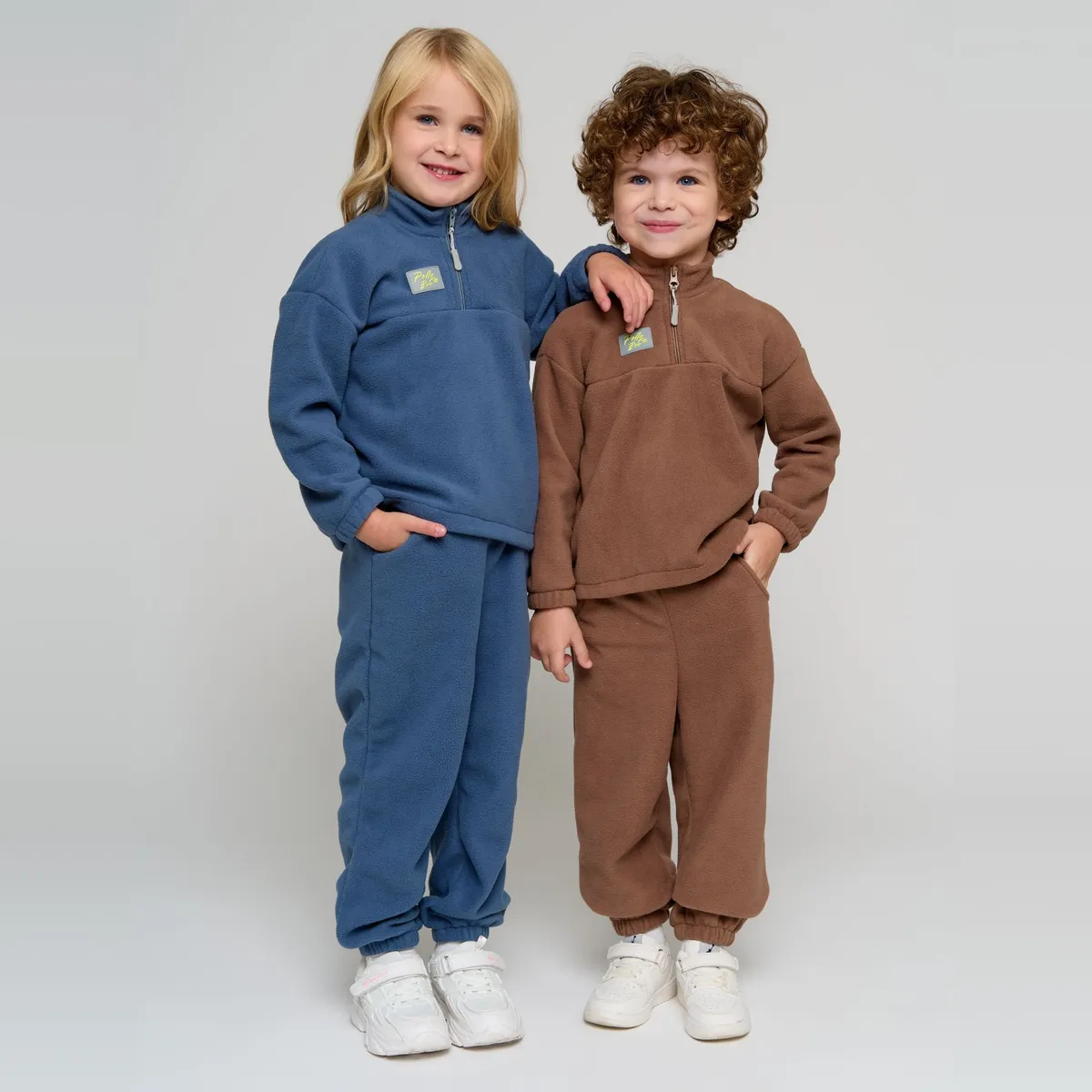 Ребёнок засовывает руки в глубокие карманы флисовой толстовки